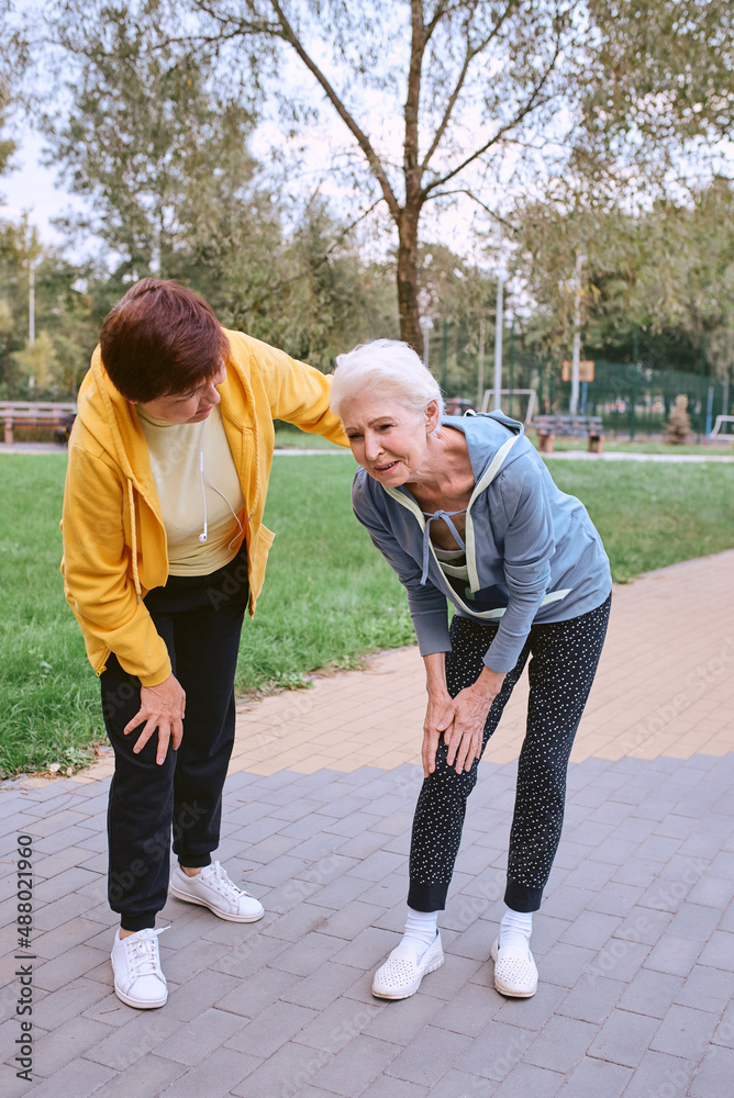 two senior women doing sports in the park, heart attack