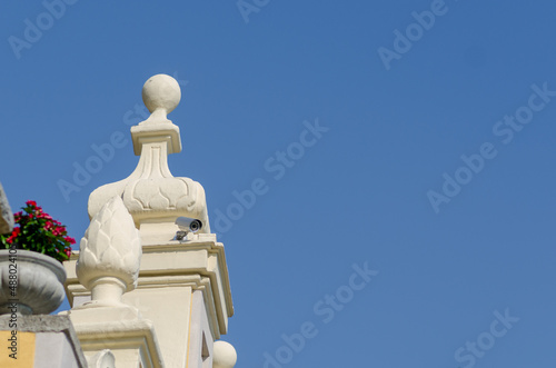 Security video surveillance, to control the areas to be observed to monitor cities, roads and private properties, Camera inserted on a prestigious historic building, seems to discreetly observe every 