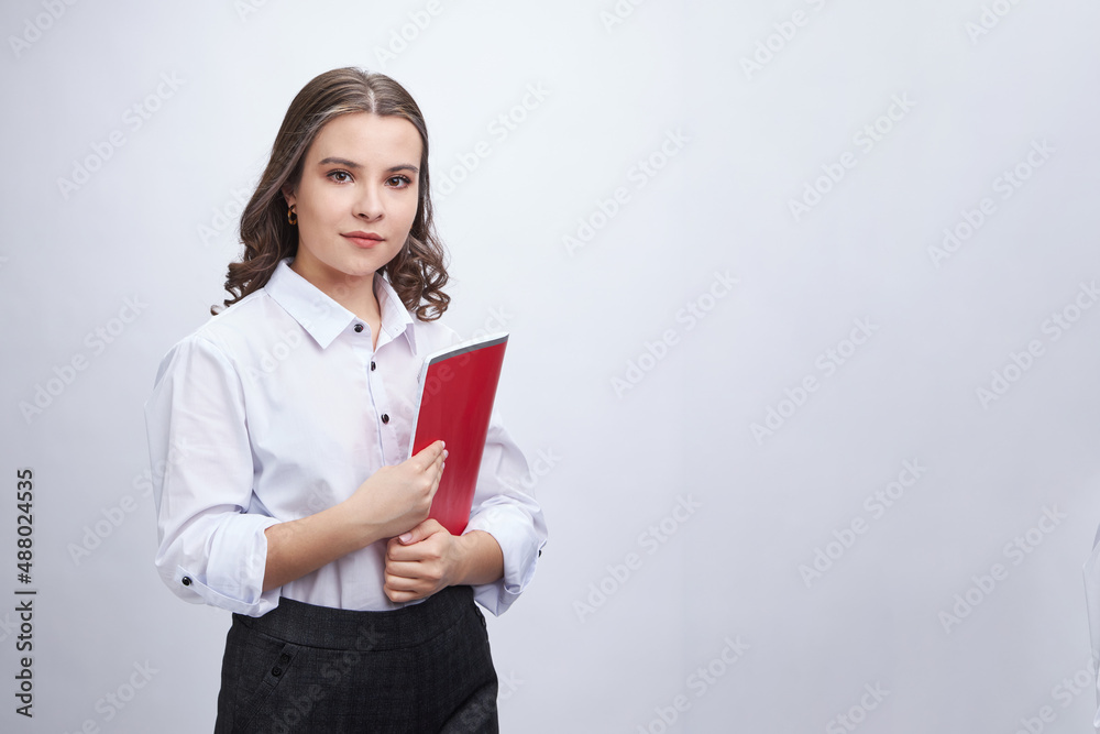 A young brunette woman, in an office outfit, in trousers and a white blouse. On a white background, isolate. A young brunette woman, in an office outfit, in trousers and a white blouse. On a white background, isolate.