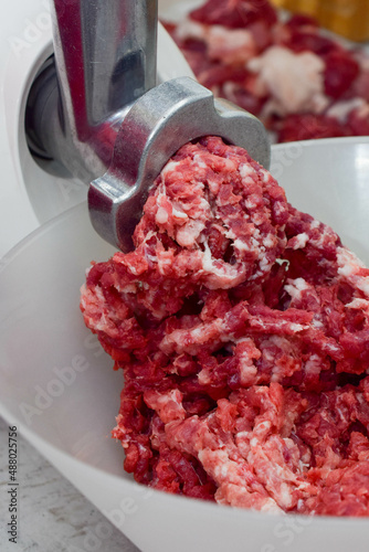 cooking minced meat in the kitchen with a meat grinder 