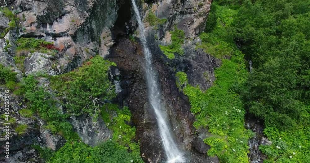 Waterfall in the mountains in the middle of a green forest. Drone vertical lift Waterfall in the mountains in the middle of a green forest. Drone vertical lift