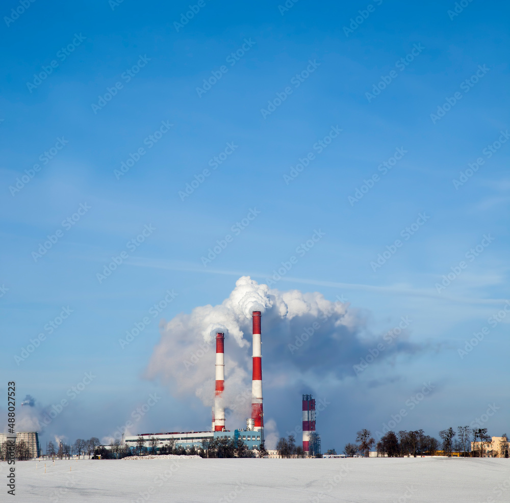 industrial pipes with white smoke in winter