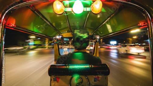 Motion time lapse view of tuk-tuk ride around Bangkok, Thailand, Southeast Asia nightlife and transportation concept. photo