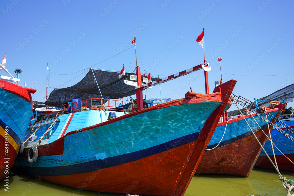 A wooden fishing boat is parked at the mouth or riverside of the Juwana River, Pati regency, Central Java, Indonesia.