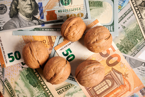 Greek nuts - photo on cash bills. Greek nuts are laying on Euro and dollar bills. Real money under fat vegetarian nutrition. Commercial result of harvest in agriculture. Real gain. Paper fiat money. photo