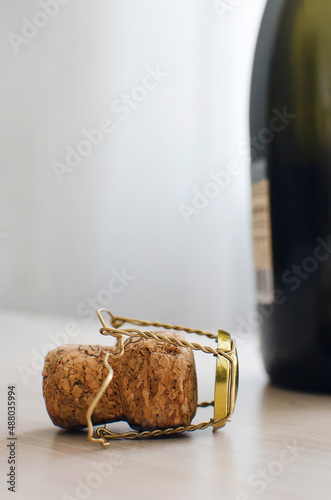 Bottle from champagne and cork on the table, Close up. The use of alcoholic beverages. Vertical photo. Place for text, copyspace.