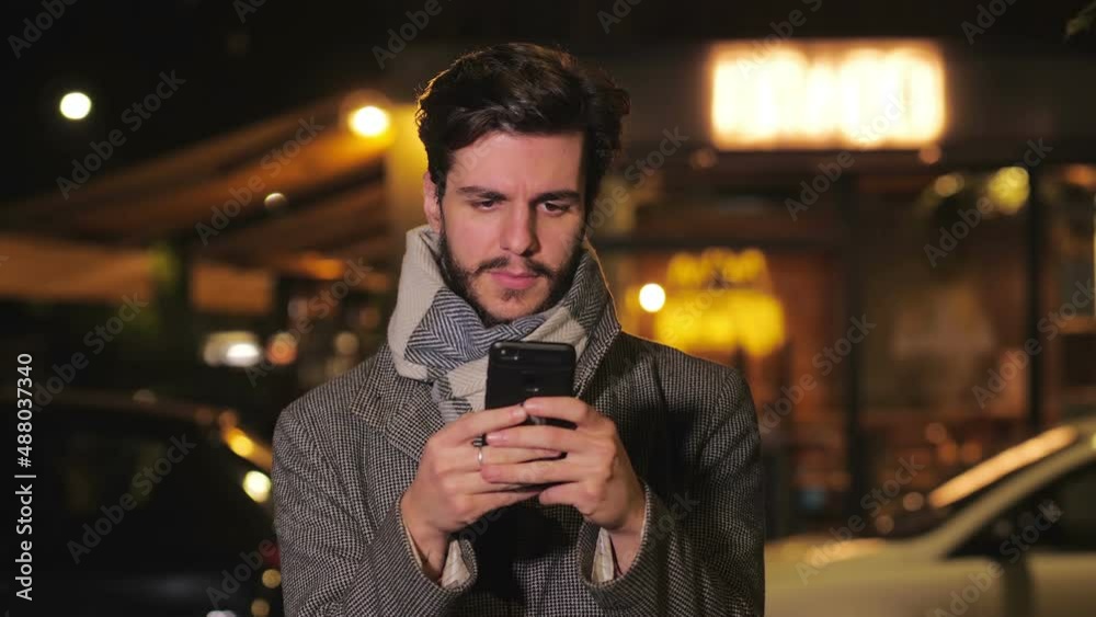 Guy writes messages and checks his smartphone Guy writes messages and checks his smartphone