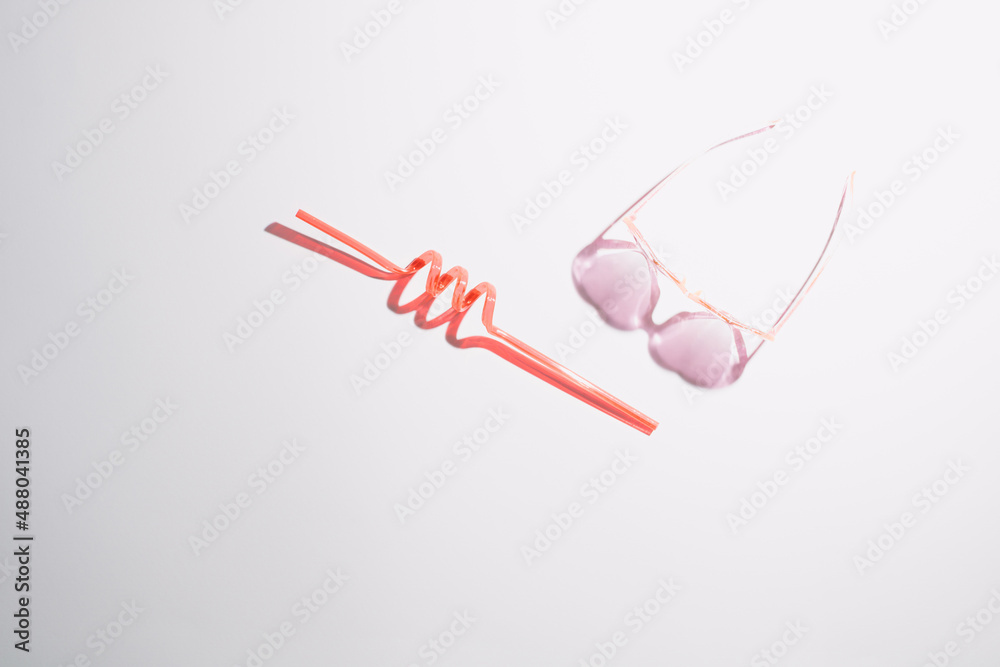 Red drink straw and heart shaped sun glasses. Tropical beach, summer, sea, vacation and travel concept with copy space. Red drink straw and heart shaped sun glasses. Tropical beach, summer, sea, vacation and travel concept with copy space.