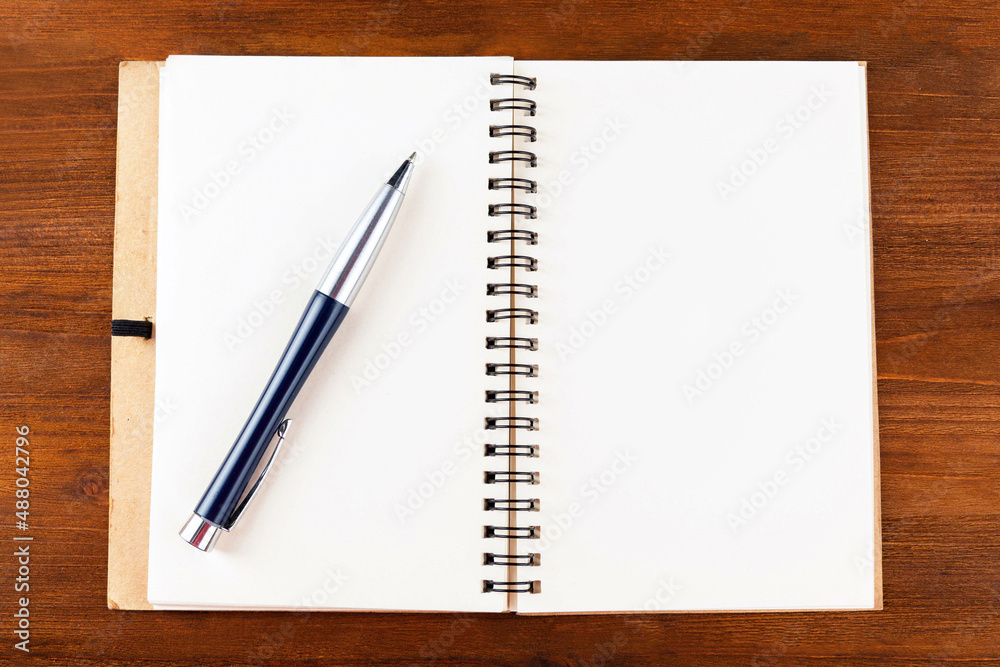 Open notepad with blank pages and a pen on a white background.Mock up.
Open notepad with blank pages and a pen on a white background.Mock up.
