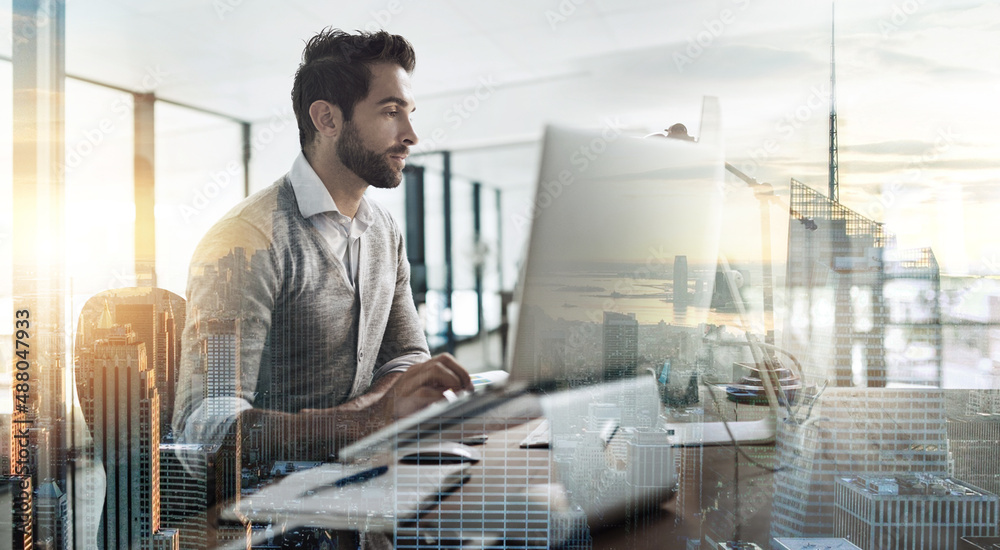 The city will be redesigned by him. Multiple exposure shot of a young businessman working in an office superimposed over a cityscape. The city will be redesigned by him. Multiple exposure shot of a young businessman working in an office superimposed over a cityscape.
