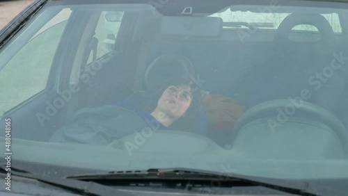 Girl wakes up drunk in the car and sleepily gets out of the car photo