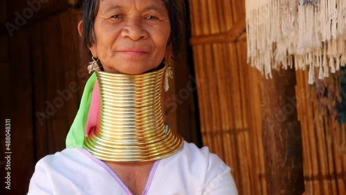 Karen Long Neck woman wearing traditional clothing and brass neck rings at hill tribe village near Chiang Rai, Thailand.
