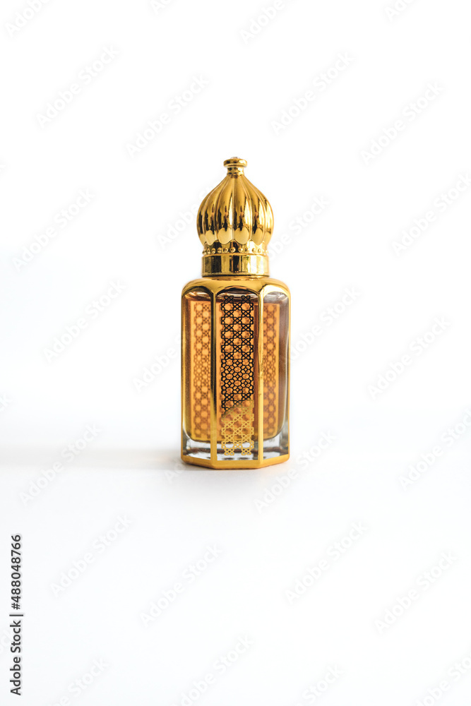 Arabian oud perfume in mini gold bottle. Isolated on white background. Copy space. Arabian oud perfume in mini gold bottle. Isolated on white background. Copy space.