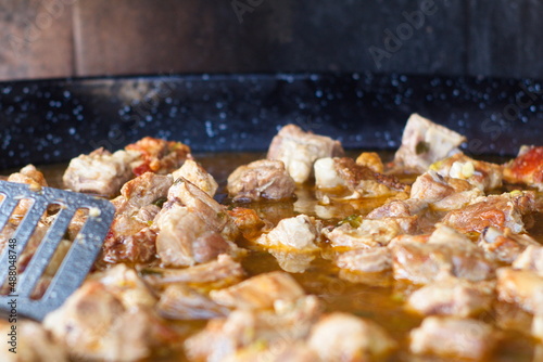 Preparation of a tasty rice with ribs with broth and pieces of pork over a wood fire