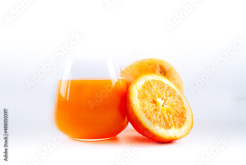 Bicchiere di spremuta di arance con due arance photo