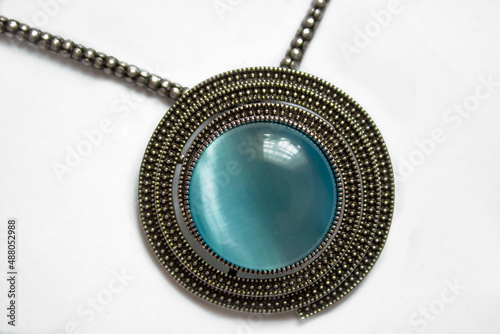 Three vintage silver drop shaped pendants with gemstones on white background