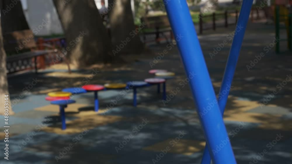 Back view of an adorable girl having fun on a swing on summer day Back view of an adorable girl having fun on a swing on summer day