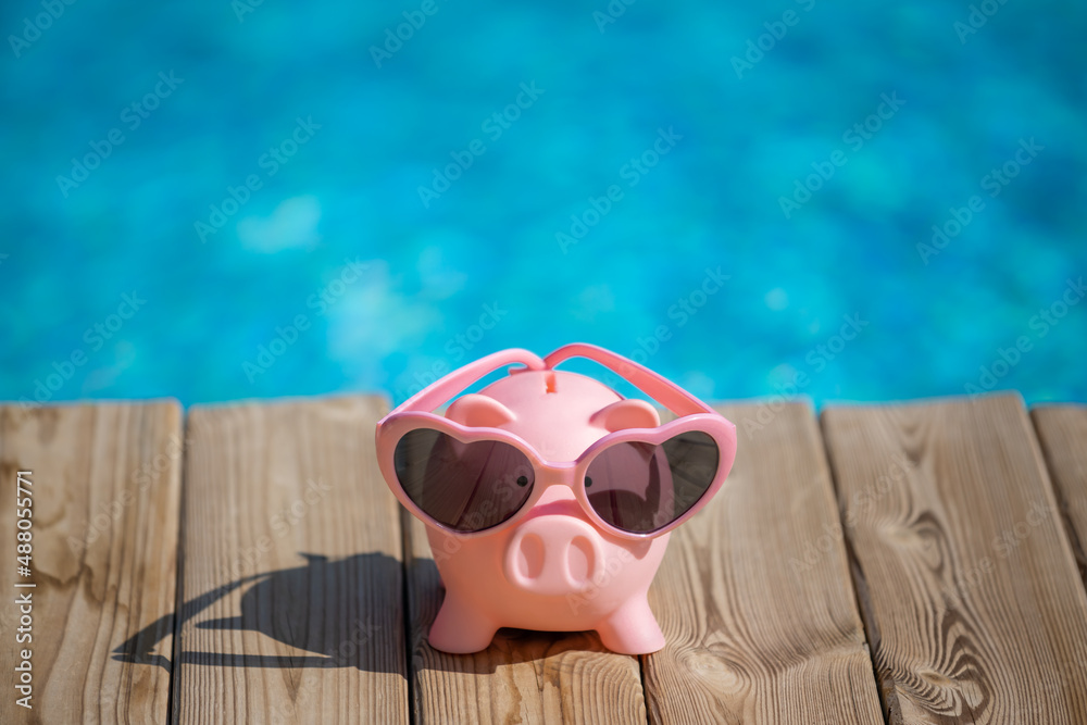 Piggybank on wood against blue water background