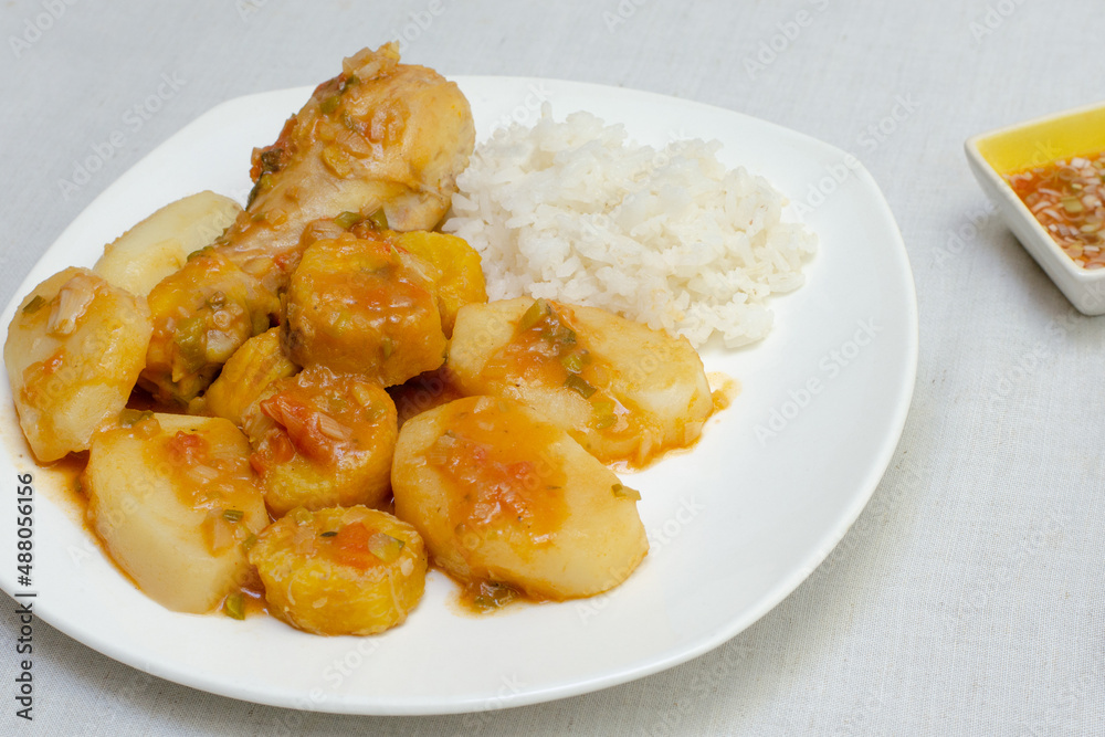 Chicken leg or thigh,potato, ripe plantain and green, vegetable sauce (tomato, onion, garlic) and spices. Typical Colombian food. Chicken stew. White plate. Sudado de pollo. White background. Chili. Chicken leg or thigh,potato, ripe plantain and green, vegetable sauce (tomato, onion, garlic) and spices. Typical Colombian food. Chicken stew. White plate. Sudado de pollo. White background. Chili.