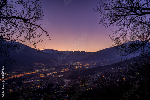 sunset over Aosta city with snow-capped mountains in the background and colorful sky