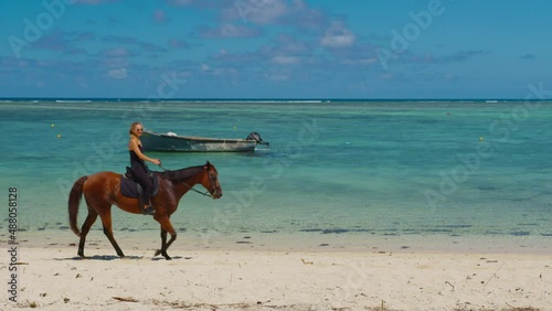 Woman riding horse on the beach. Slow motion video. Sport and travel concepts. Beautiful young woman horseback riding on the beach.