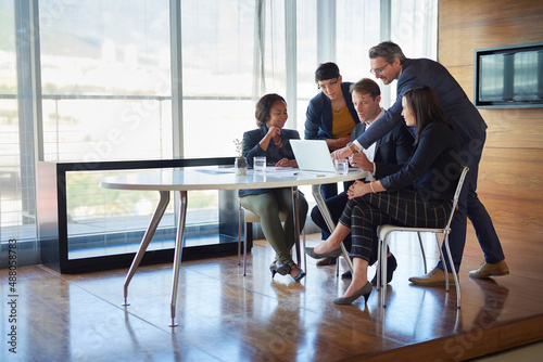 Giving his input. Shot of a group of corporate businesspeople working in the boardroom.