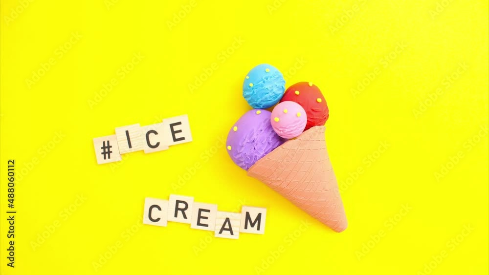 Plasticine stop motion animation. Multicolored plasticine ice cream on a yellow background, claymotion