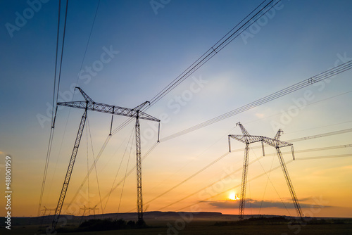 High voltage towers with electric power lines at sunset