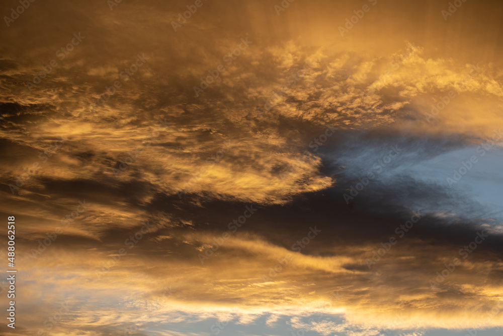 des nuages jounes et orangés sous un ciel bleu en fin de journée