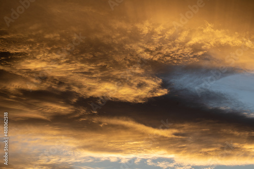 des nuages jounes et orangés sous un ciel bleu en fin de journée photo