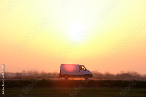 Small cargo van driving on highway hauling goods. Delivery transportation and logistics concept © bilanol