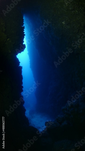 cave diving underwater scuba divers exploring caves and having fun ocean scenery sun beams and rays background © underocean