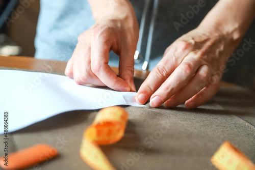 Working process of a dressmaker. Closeup photo of craftsperson's hands