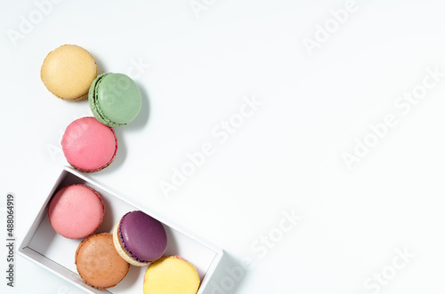 Sweet colorful macarons isolated on white background. Tasty colorful macaroons. Top view.