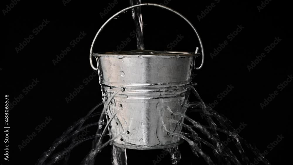 tin bucket with holes on black, real time