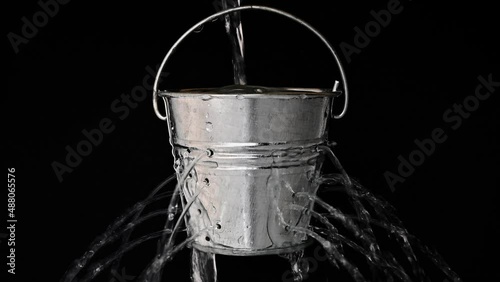 tin bucket with holes on black, real time