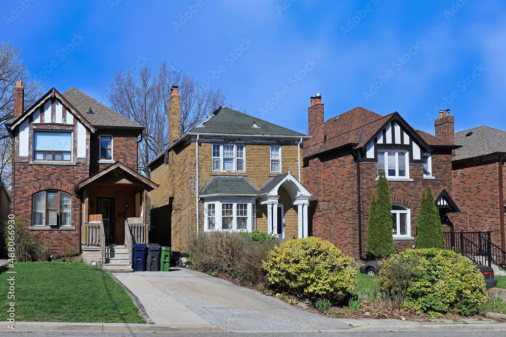 Residential street with older two story brick detached houses in spring