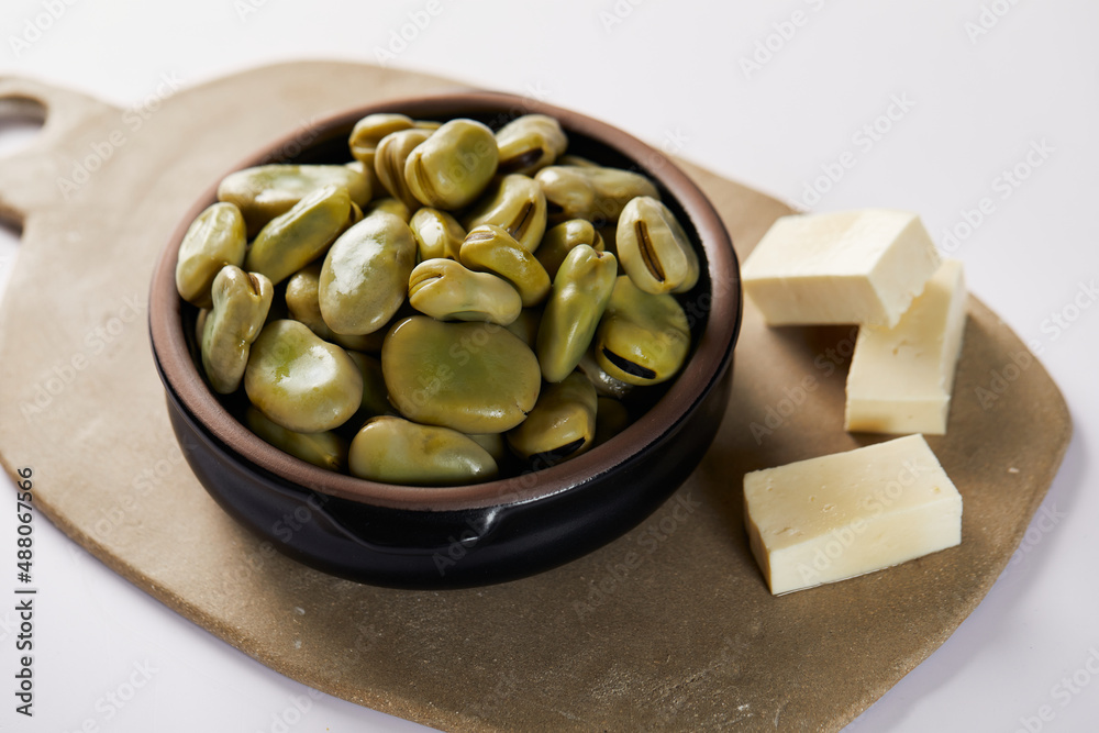 Broad beans with cheese, traditional Ecuadorian appetizer served in a typical deep dish with a white background Broad beans with cheese, traditional Ecuadorian appetizer served in a typical deep dish with a white background