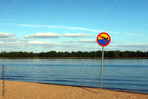 Sign prohibiting swimming on the beach by the shore of a lake or river