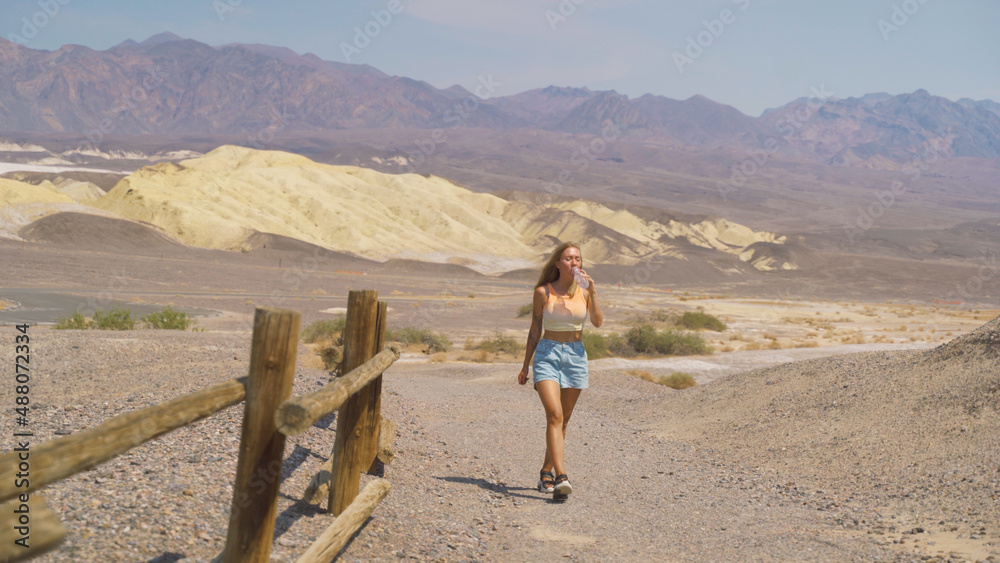 Young pretty woman exploring remains of industrial workings at the old Harmony Borax mine works in Death Valley National Park, California, USA.