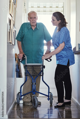 When the going gets tough, Ill help you get going. Shot of a female nurse assisting her senior patient whos using a walker for support. © Nola Viglietti/peopleimages.com