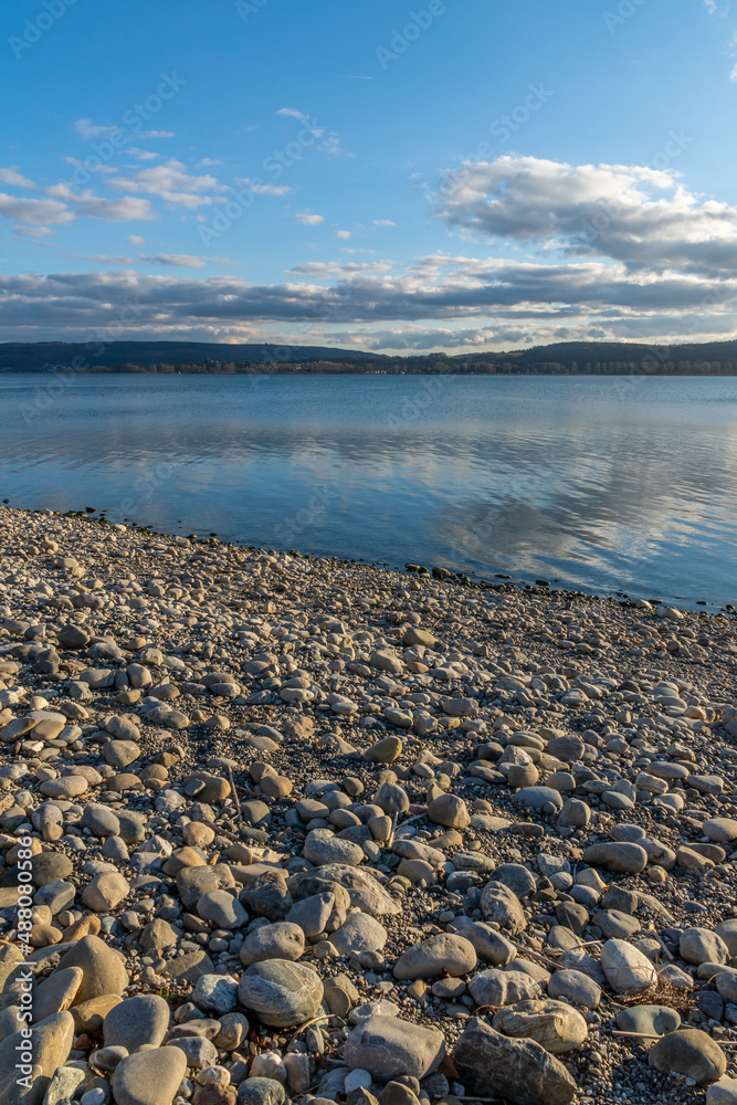 Steine am Seeufer des Bodensee mit blauen Himmel und Sonnenschein 