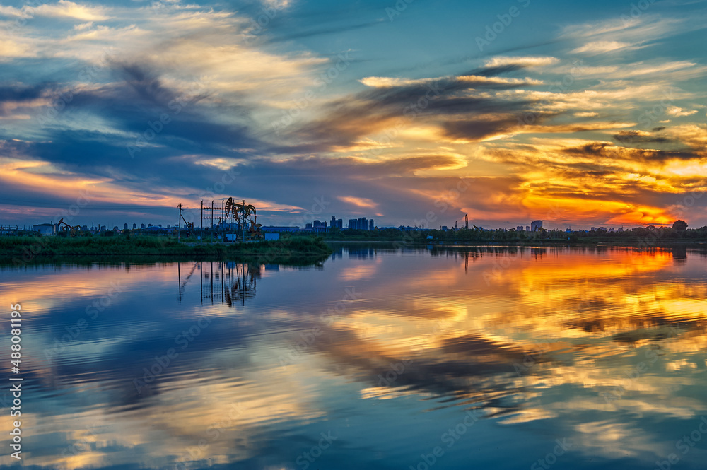 The oil sucking machines at lakeside sunrise in Daqing oil fields, China. The oil sucking machines at lakeside sunrise in Daqing oil fields, China.