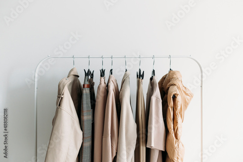 capsule clothes of beige coloron a rack. Closeup