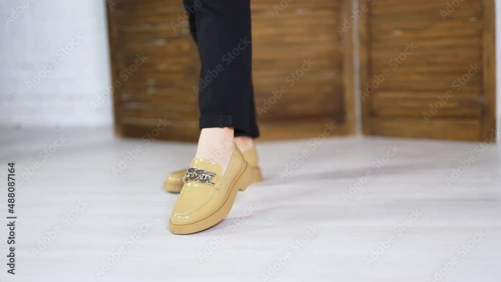 Presentation of beautiful new beige shoes with silver chain decoration. Lady model in black jeans demonstrates footwear. Close up. Presentation of beautiful new beige shoes with silver chain decoration. Lady model in black jeans demonstrates footwear. Close up.
