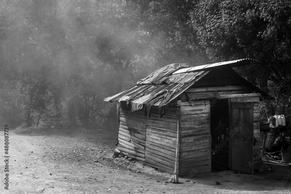 Dramatic black and white image of a old wooden weathered cooking shack high in the Caribbean mountains with clothes drying on the hot metal roof. Dramatic black and white image of a old wooden weathered cooking shack high in the Caribbean mountains with clothes drying on the hot metal roof.