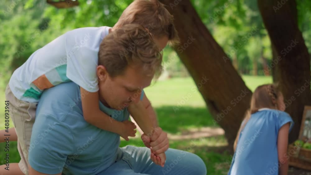 Playful son riding on back blond man closeup. Smiling father lift up cute boy. Playful son riding on back blond man closeup. Smiling father lift up cute boy.