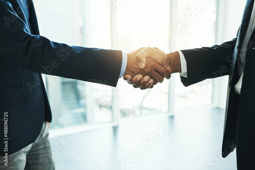 Reaching their business goals together. Shot of two unrecognisable businessmen shaking hands in an office.