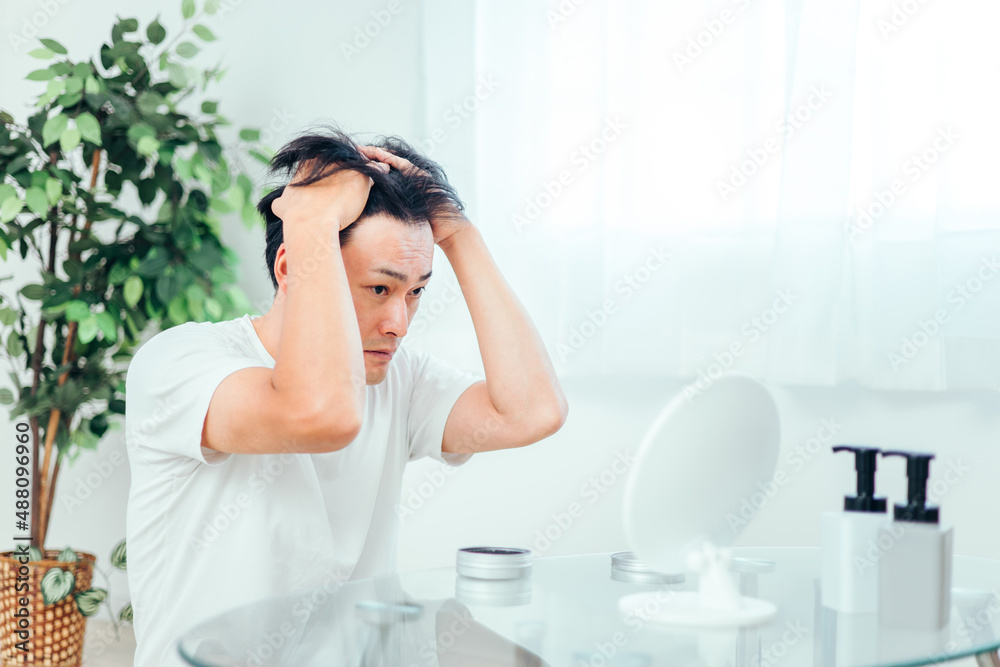 ヘアセットする男性(悩む)
ヘアセットする男性(悩む)