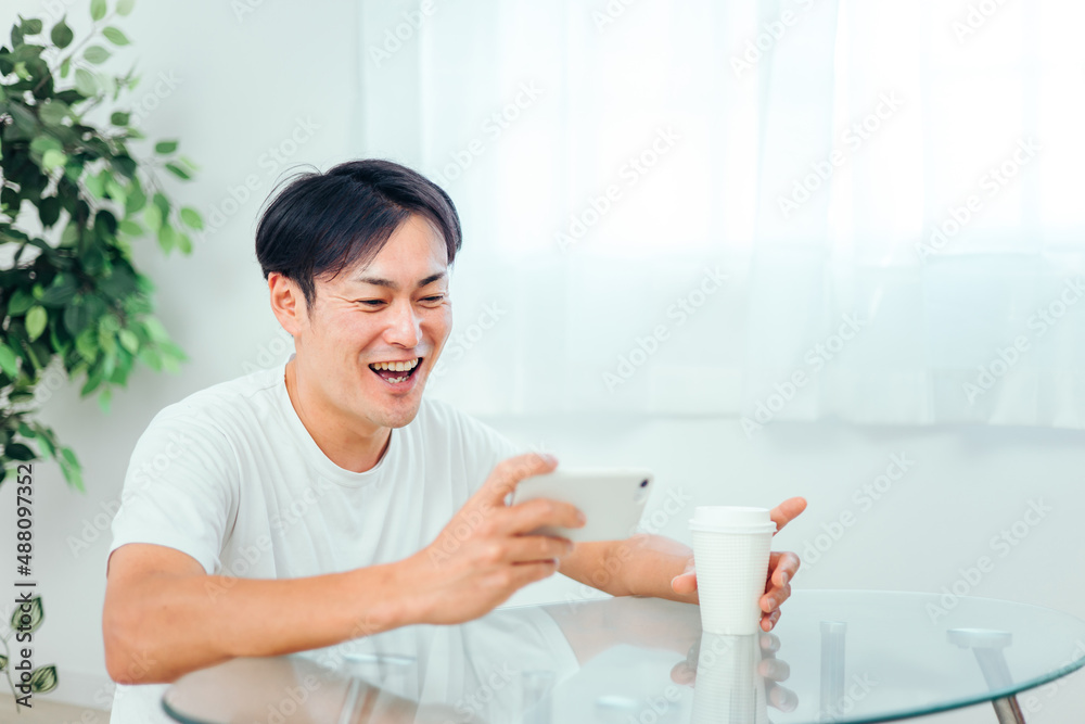 部屋でスマホを見る男性（爆笑）
